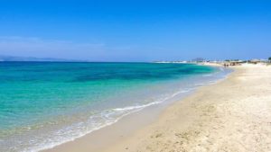 Plaka beach is long and wide, with white expanse of sand and turquoise water.