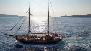 Unwind and Relax on a Traditional Wooden Sailing Ship in Santorini's Crystal Waters